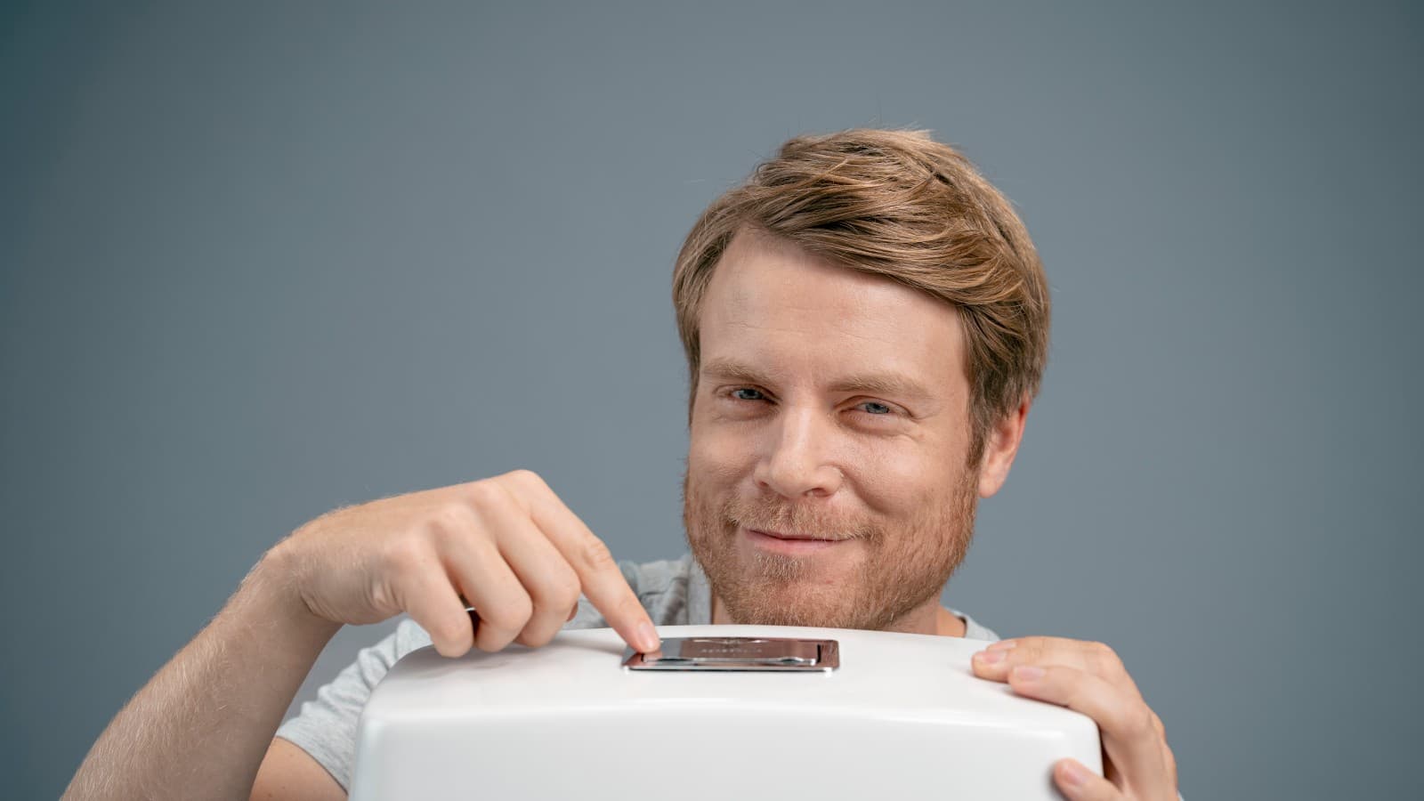 Mann og en toalettskylleknapp Mann og en toalettskylleknapp